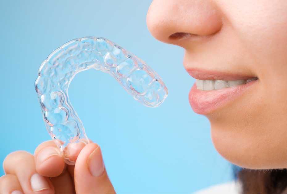 Woman holding clear aligner near mouth for teeth straightening