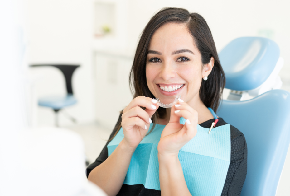 Patient holding clear teeth aligners during invisible braces consultation in the UK