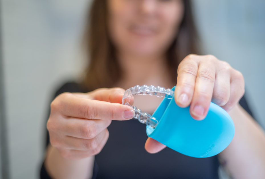 Woman holding clear dental aligners with blue case – Smileie UK